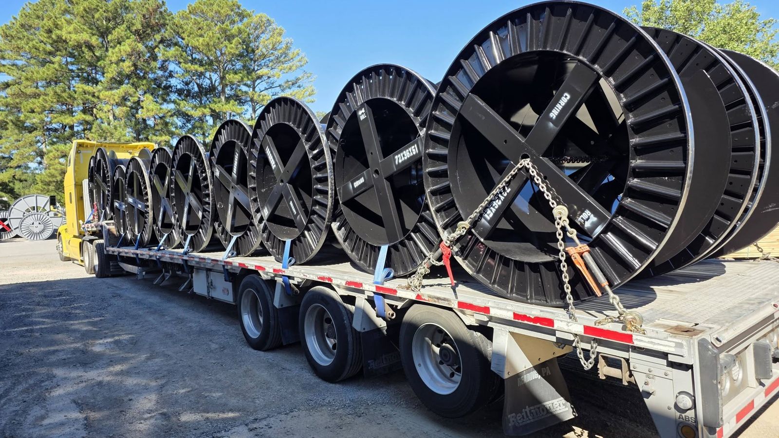 Cable spools loaded across the deck, each one chocked and strapped.
